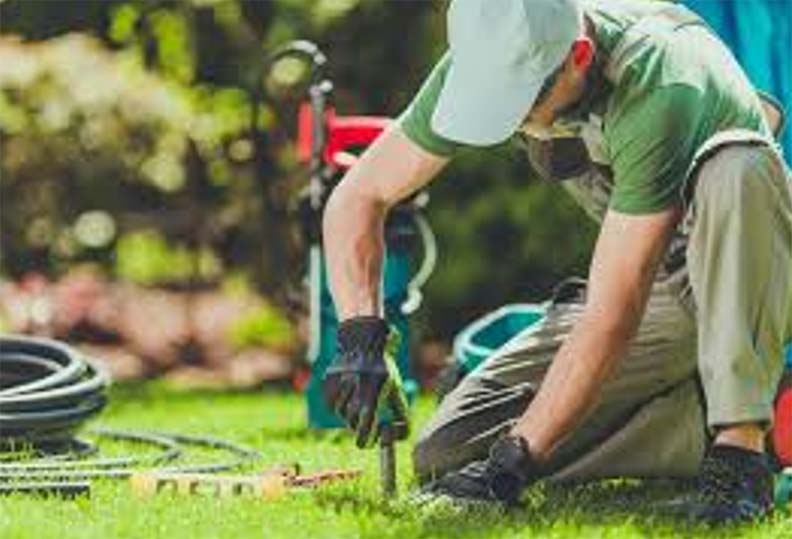 <Home Services For You Professional Technician maintaining an underground sprinkler system, ensuring proper installation and function.>